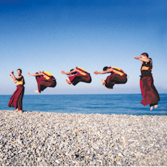 585. On a bright winter morning, Tibetan and Bhutanese monks jump for joy at the sight of the ocean. They will throw themselves up in the air again this evening, on the stage of a theatre in Brittany, France, defying gravity. This image is not a multiple exposure, but a single shot of seven monks jumping. 1997 Les moines volants du Toit du Monde devant l’océan Atlantique ; moines du monastère de Shéchèn au cours d’une tournée européenne de danses sacrées. 1997